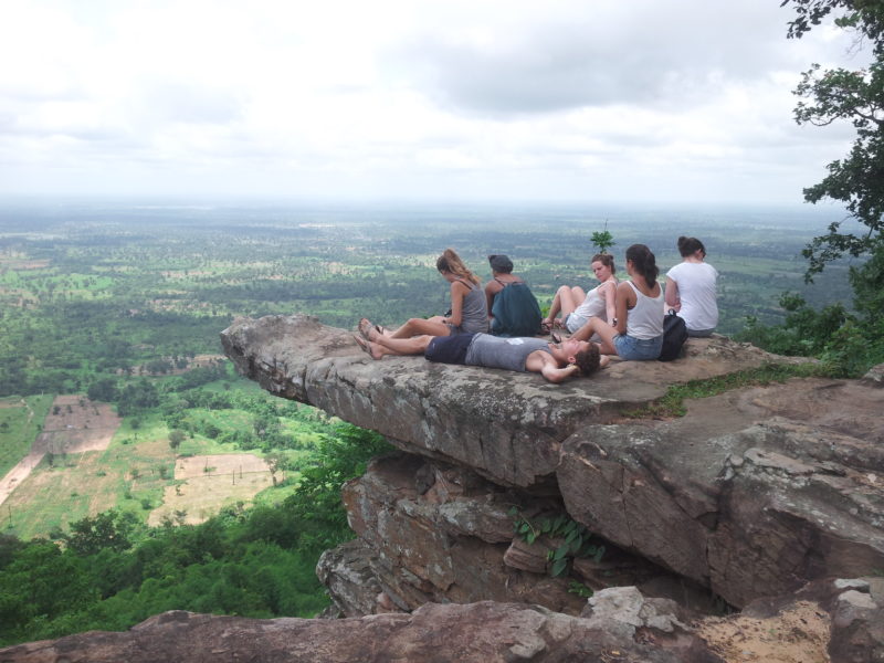 5 volunteers on the cliff looking out to distant cambodia