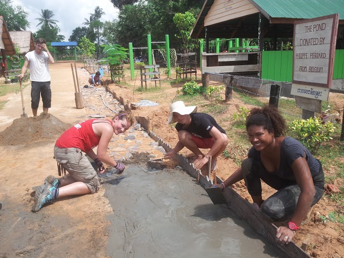 volunteers laying the path outside rural school cambodia