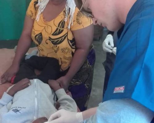 volunteer treating a wound on medical project, Tanzania