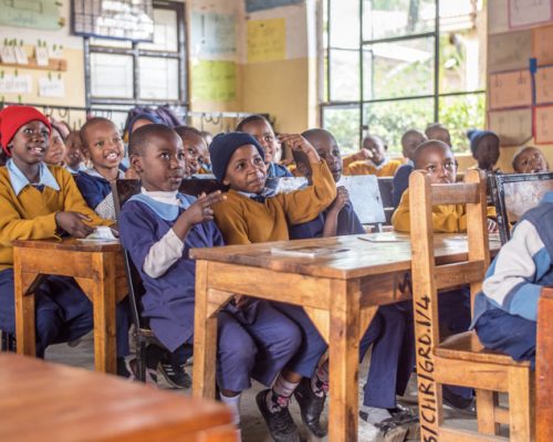 Students sit on their desk 1 olm74vqtoo76rveefssg7h3cl7n7f3y6bckym31w9s - English Teaching Tanzania