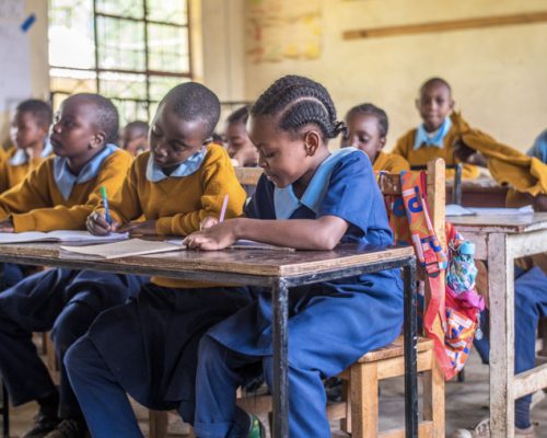 Students sit on their desk 11 olm75bq2wut298r6uhp3vv26orgg1ypm1jo7rse7c0 - English Teaching Tanzania