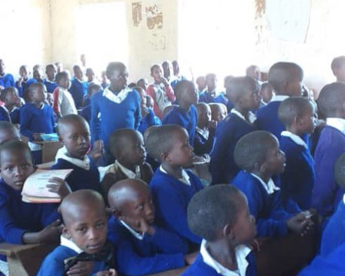 Students sit on their desk ol343rb0mof2ann3i9rcsaiulo27dq5wtr6l6l3n34 - English Teaching Tanzania